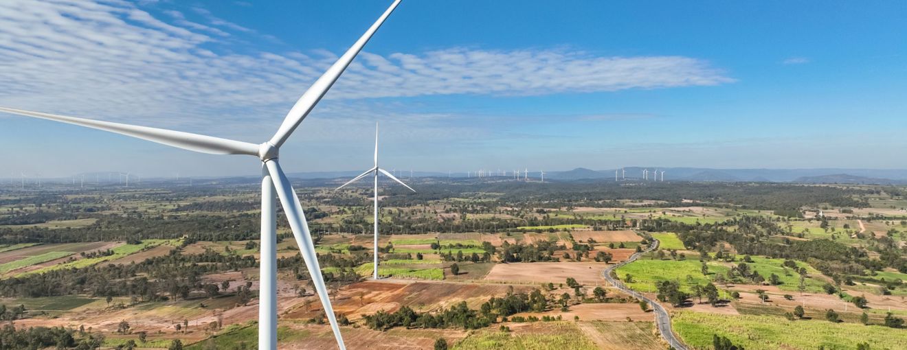Wind turbines across a wide rural landscape on a clear, sunny day