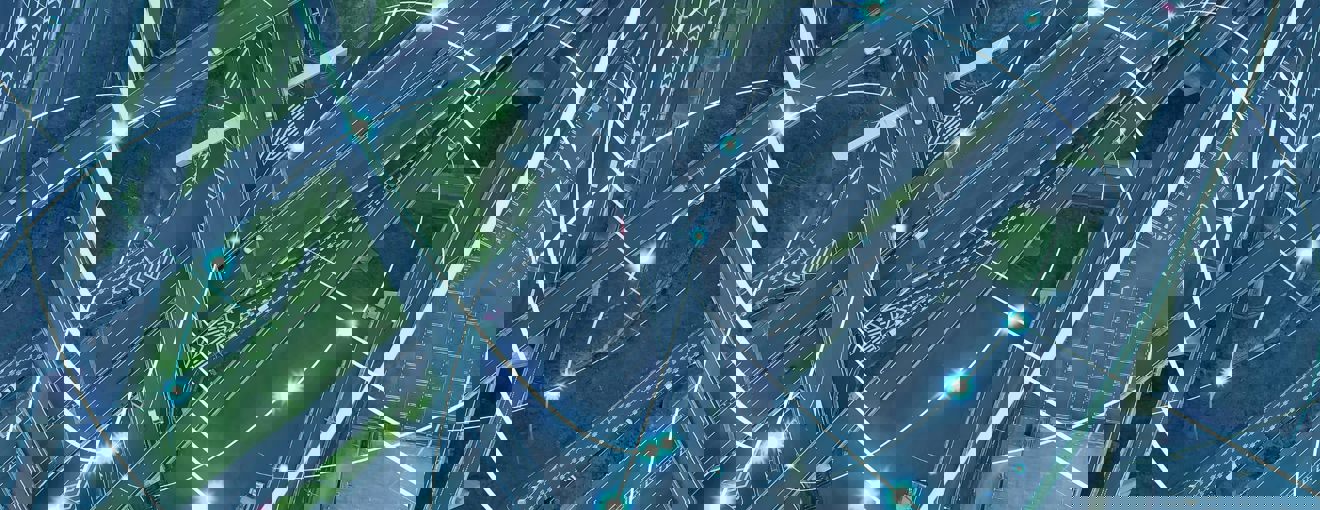 Aerial view of a motorway interchange, overlaid with glowing digital network lines