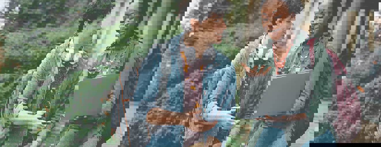 Two people smiling at a laptop