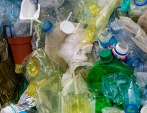 Pile of mixed plastic waste including bottles, containers, and packaging materials