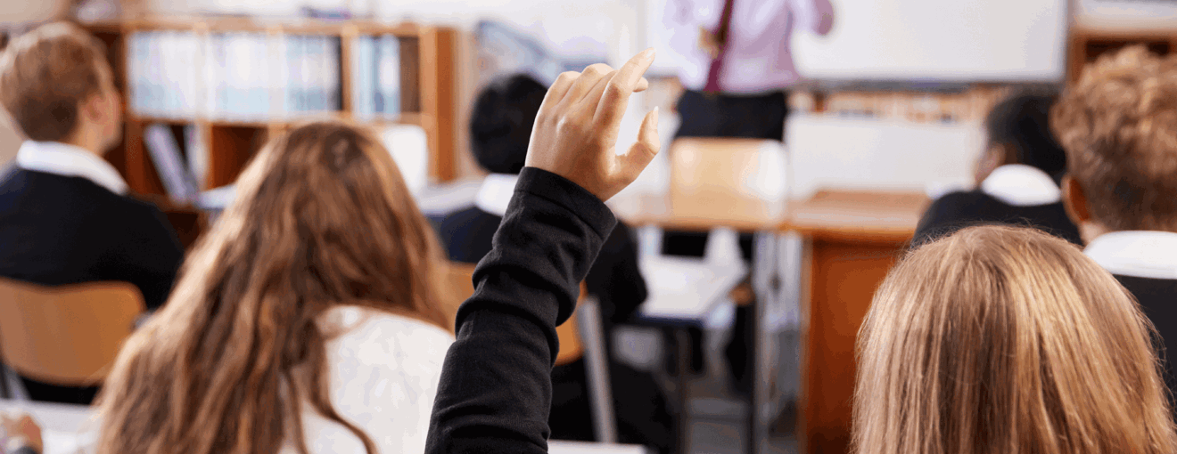 Students in a classroom with their hands raised