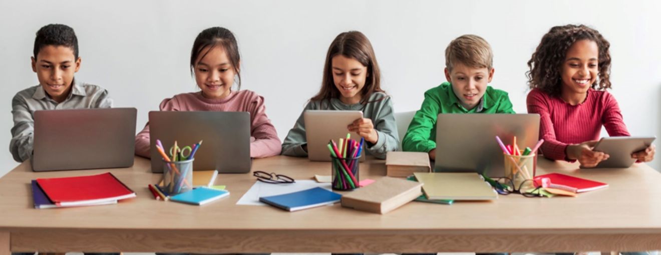 School children in a classroom using digital devices