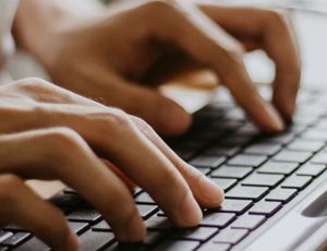 Person typing on a keyboard