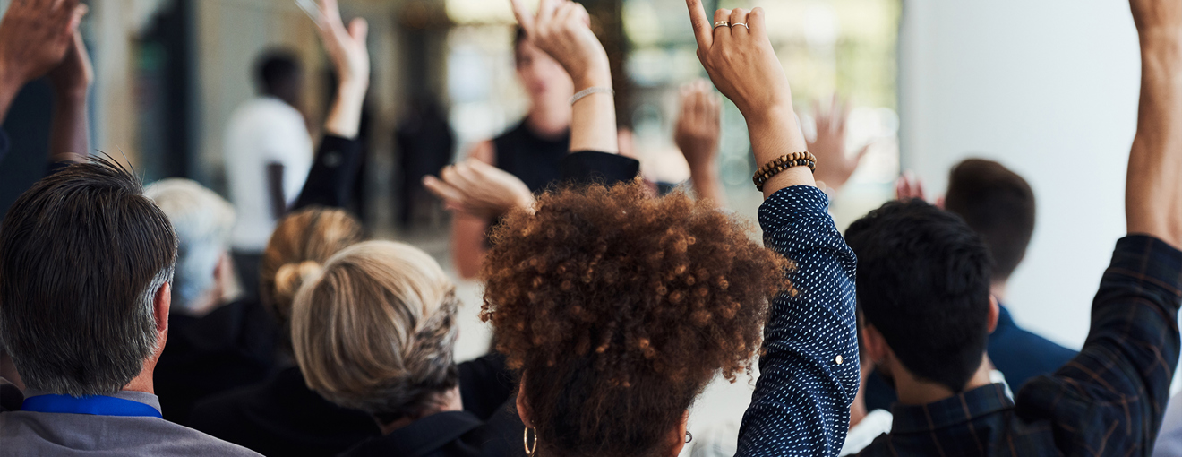 A group of employees with their hands raised
