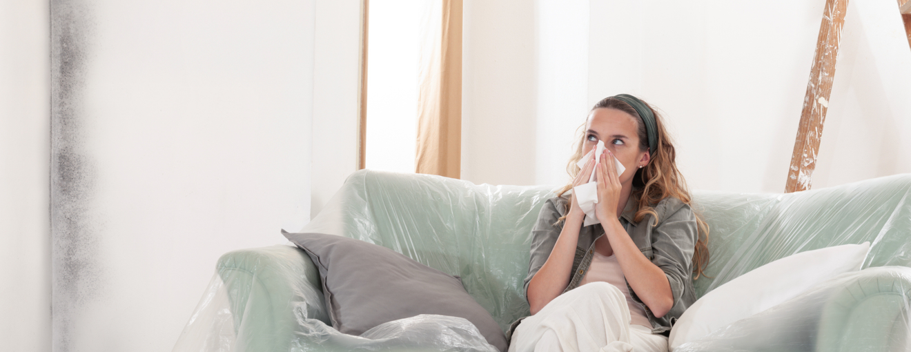 A person sat on the sofa with black mould